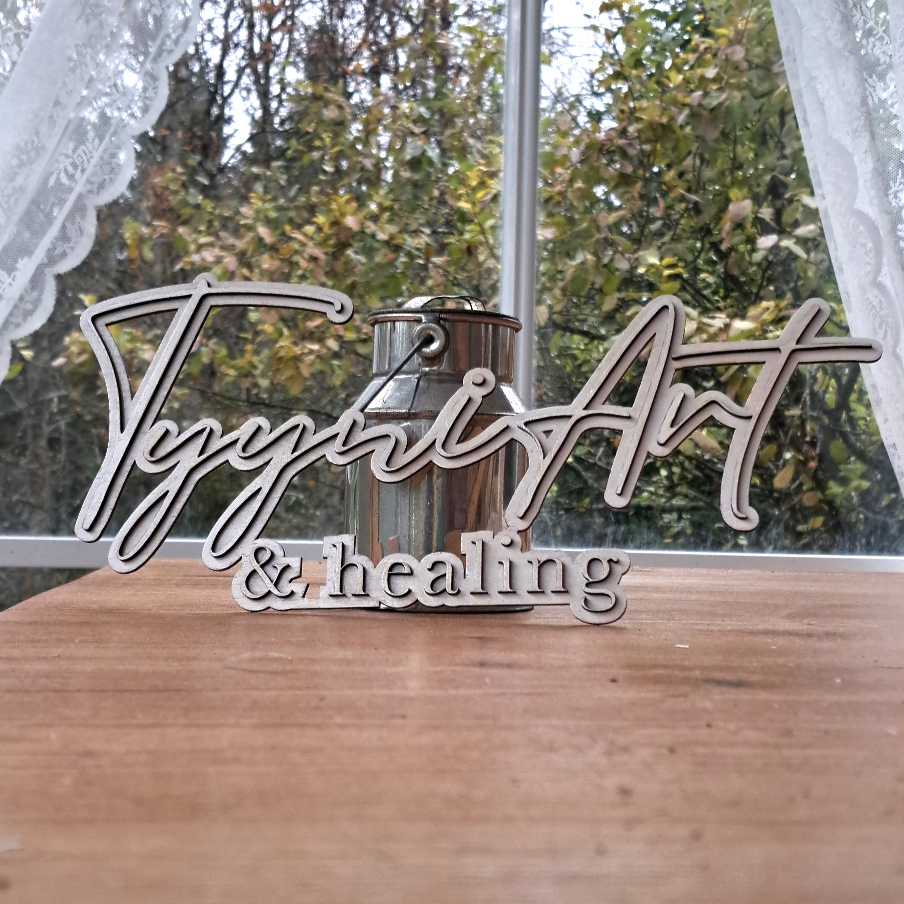 TyyniArt & healing -kyltti irrallaan pöydällä